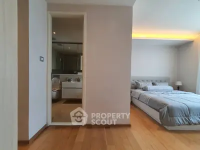 Spacious bedroom with ensuite bathroom and modern wooden flooring