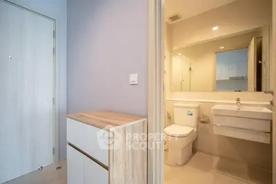 Modern bathroom with sleek fixtures and light wood accents in a contemporary apartment.