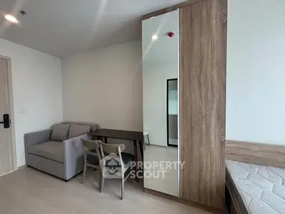 Modern studio apartment with cozy sofa, dining table, and mirrored wardrobe