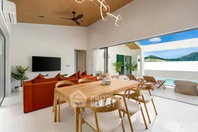 Luxurious open-plan living room with modern furniture and stunning mountain view from the balcony.