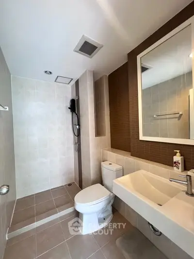 Modern bathroom with sleek fixtures and walk-in shower in a contemporary home.