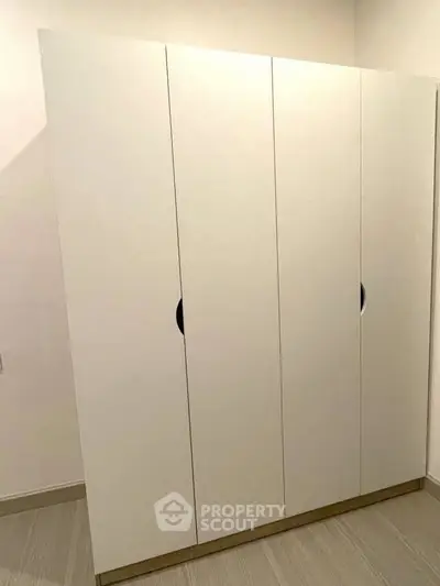Modern white wardrobe with sleek design in a contemporary interior setting.
