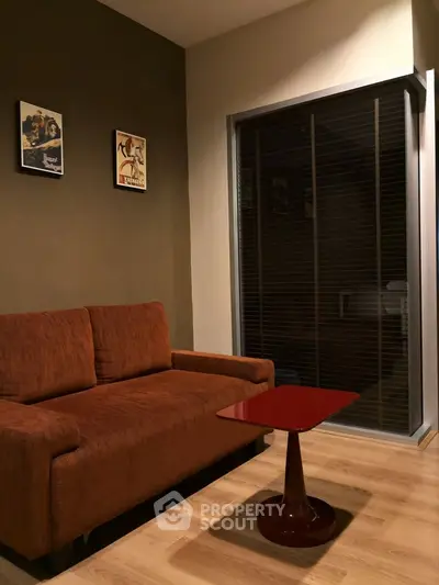 Cozy living room with brown sofa and modern red coffee table.