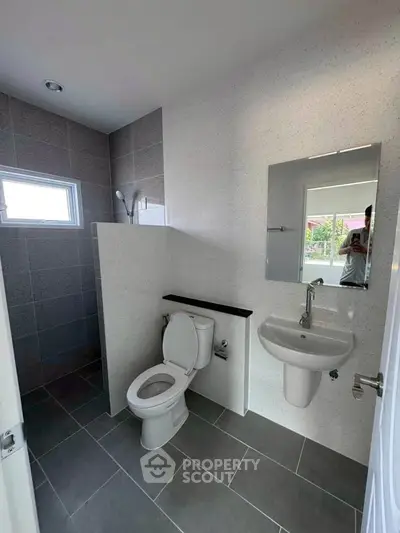 Modern bathroom with sleek design, featuring a wall-mounted sink and contemporary fixtures.