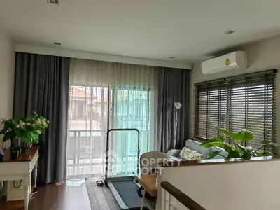 Charming living room with balcony view, cozy decor, and natural light
