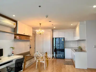 Modern open-plan living room with stylish kitchen and elegant chandelier