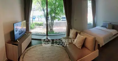 Modern studio apartment with cozy living area and garden view