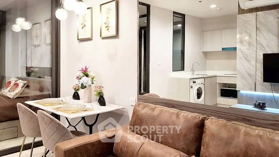 Modern open-plan living room with stylish kitchen and cozy dining area in a contemporary apartment.
