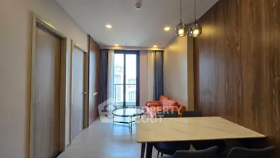 Modern living room with stylish furniture and large window offering city views.