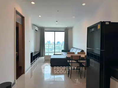 Modern living room with city view, sleek furniture, and natural light in a high-rise apartment.