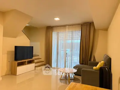 Spacious living room with modern decor and large windows