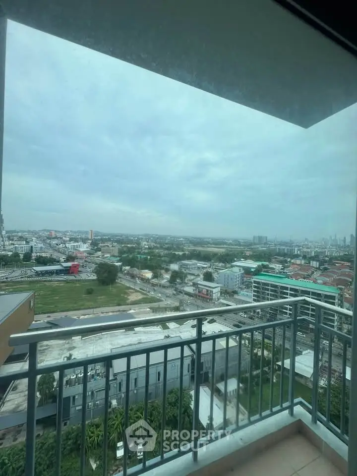 Stunning high-rise balcony view overlooking cityscape and lush greenery, perfect for urban living.