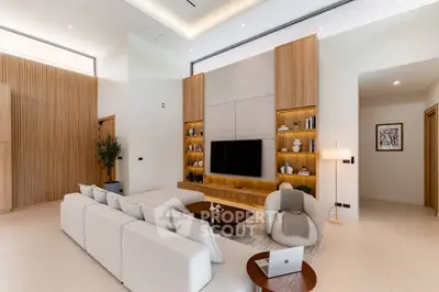 Luxurious modern living room with high ceilings, elegant furniture, and built-in wooden shelving.