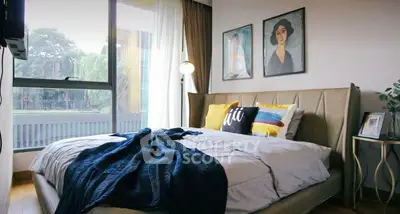 Stylish bedroom with large window and modern decor, perfect for relaxation and comfort.