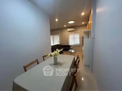 Modern dining area with elegant table setting and cozy living room view