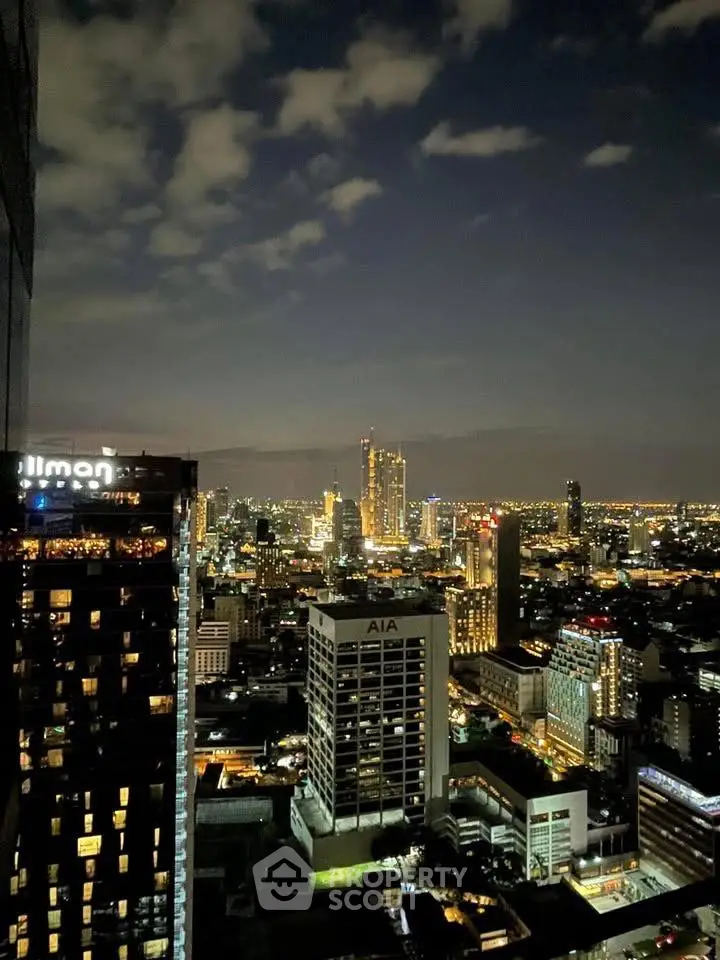 Stunning cityscape view from a high-rise building at night, showcasing vibrant urban lights.