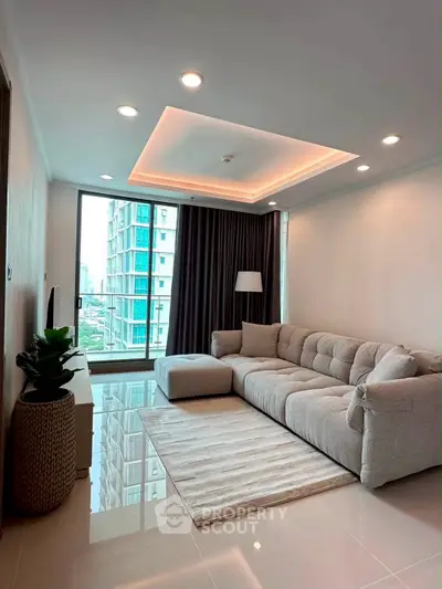 Modern living room with plush sofa and city view, featuring elegant lighting and sleek flooring.