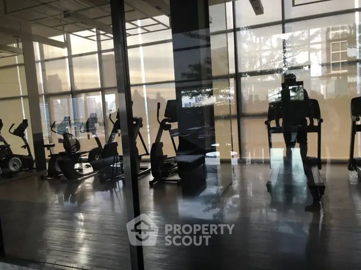 Modern gym with state-of-the-art equipment and city view, perfect for fitness enthusiasts.