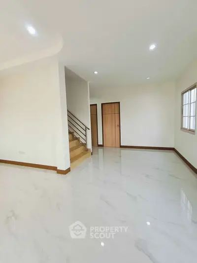 Spacious modern living room with marble flooring and staircase