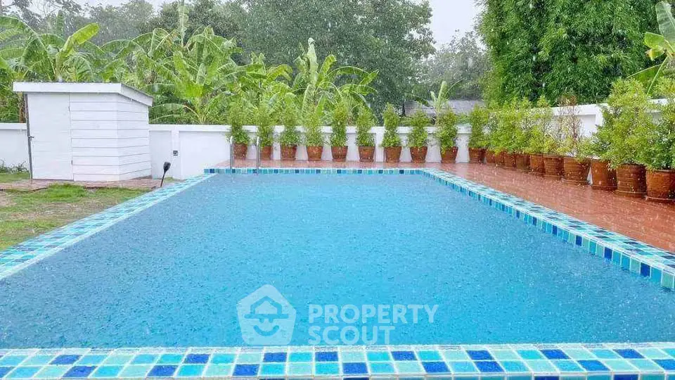 Stunning outdoor pool surrounded by lush greenery and elegant tile work, perfect for relaxation and entertainment.