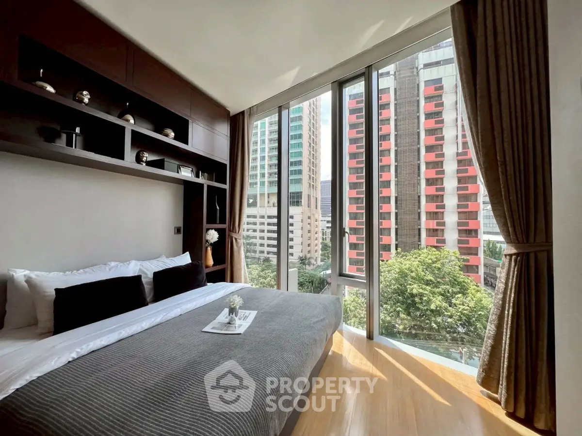 Luxurious bedroom with floor-to-ceiling windows offering stunning city views.