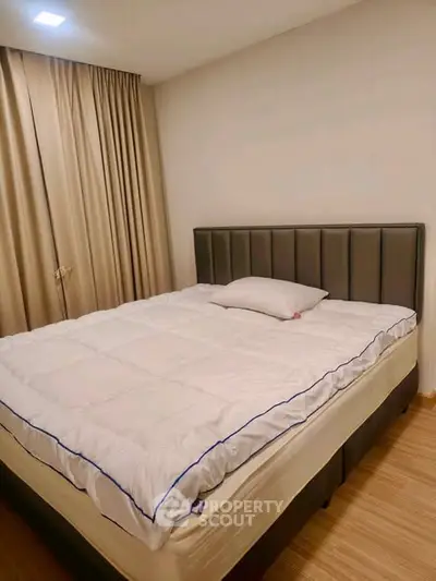 Cozy bedroom with modern bed and elegant curtains, perfect for restful nights.