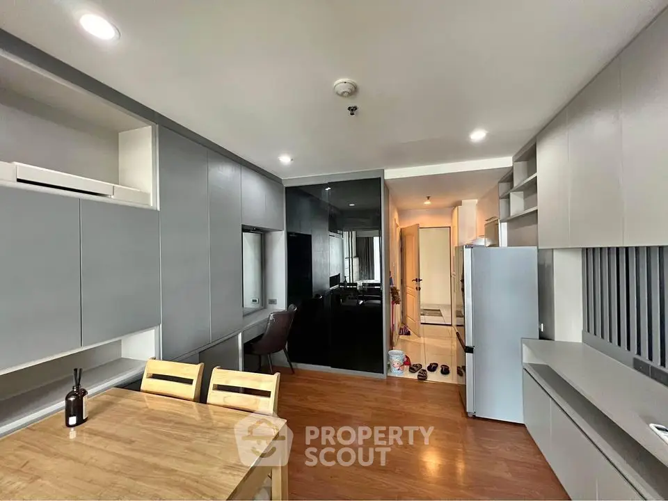 Modern kitchen with sleek cabinetry and dining area in stylish apartment