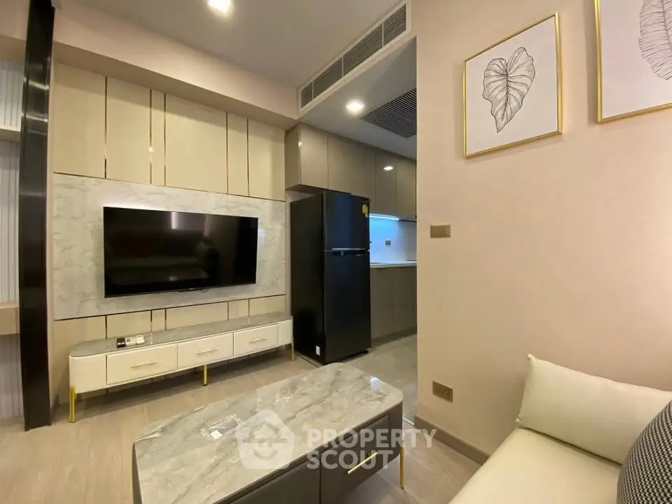 Modern living room with sleek TV unit and cozy seating area in a stylish apartment.
