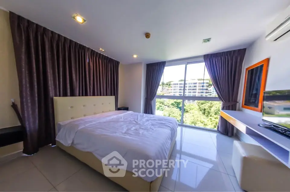 Spacious bedroom with large window and modern decor