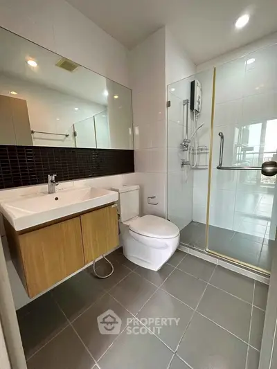Modern bathroom with sleek design, featuring a glass shower enclosure and stylish vanity.