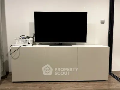 Modern living room with sleek TV stand and flat-screen TV, perfect for entertainment setup.
