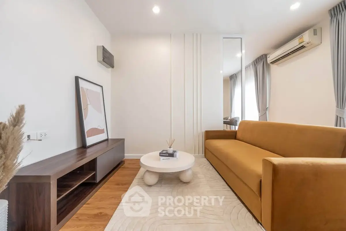 Modern living room with stylish decor, featuring a mustard sofa, sleek wooden furniture, and elegant lighting.