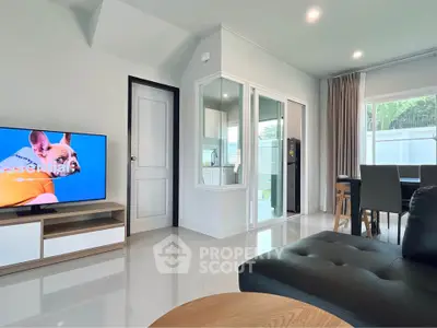 Modern living room with sleek furniture and large TV, bright and inviting space.