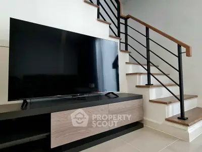 Modern living room with sleek TV unit and stylish staircase design
