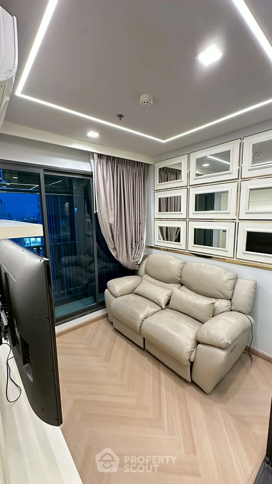 Modern living room with cozy leather sofa and mirrored wall accents