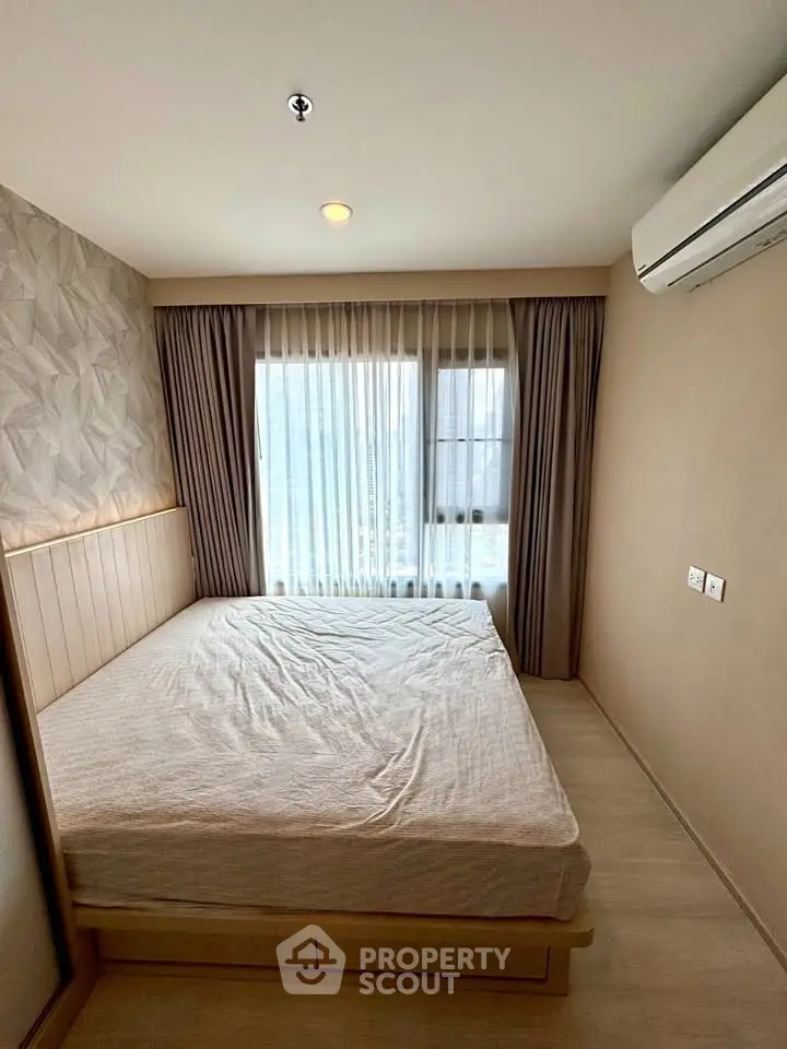 Cozy bedroom with modern decor and large window for natural light