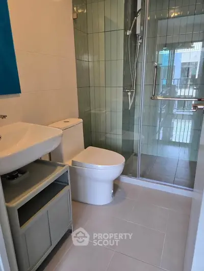 Modern bathroom with glass shower and sleek fixtures in a contemporary apartment.