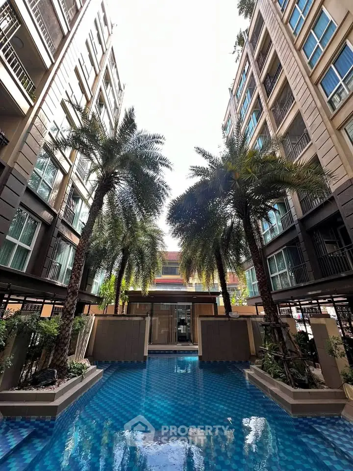 Luxurious apartment complex with stunning pool and palm trees, perfect for modern living.