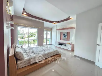 Spacious bedroom with modern decor and large windows offering natural light and garden view.