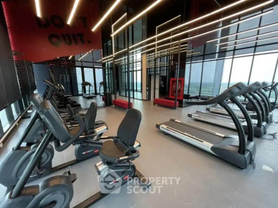 Modern gym with state-of-the-art equipment and panoramic windows in luxury building.