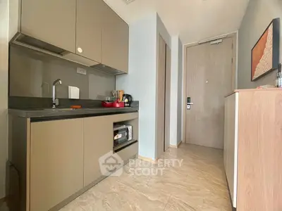 Modern compact kitchen with sleek cabinetry and integrated appliances in a stylish apartment.