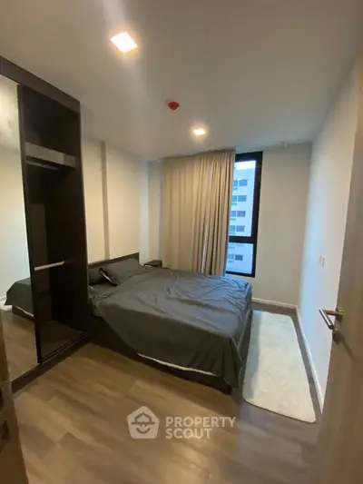 Modern bedroom with sleek design and large window in urban apartment