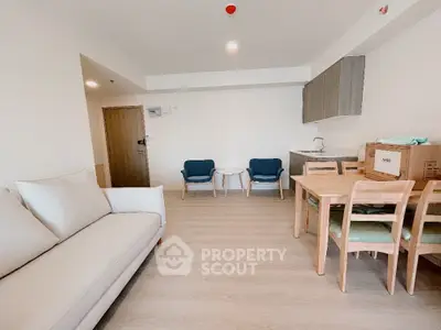 Modern living room with cozy seating and dining area in open layout apartment.