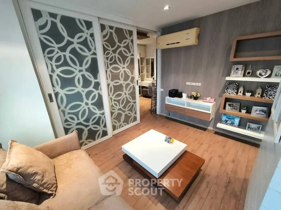 Modern living room with stylish decor and sliding doors in a cozy apartment.