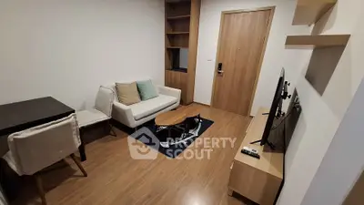 Modern living room with cozy sofa, TV, and wooden flooring in a stylish apartment.