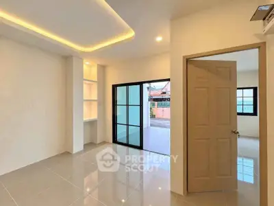 Modern interior with sleek tile flooring and recessed lighting, featuring a spacious open layout and large windows.