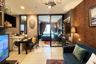 Modern living room with open layout and view into cozy bedroom, featuring stylish decor and washing machine.