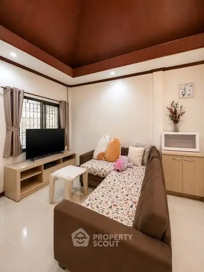 Cozy living room with modern sectional sofa and flat-screen TV, perfect for relaxation and entertainment.
