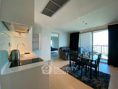 Modern open-plan kitchen and living room with city view, sleek design and natural light.