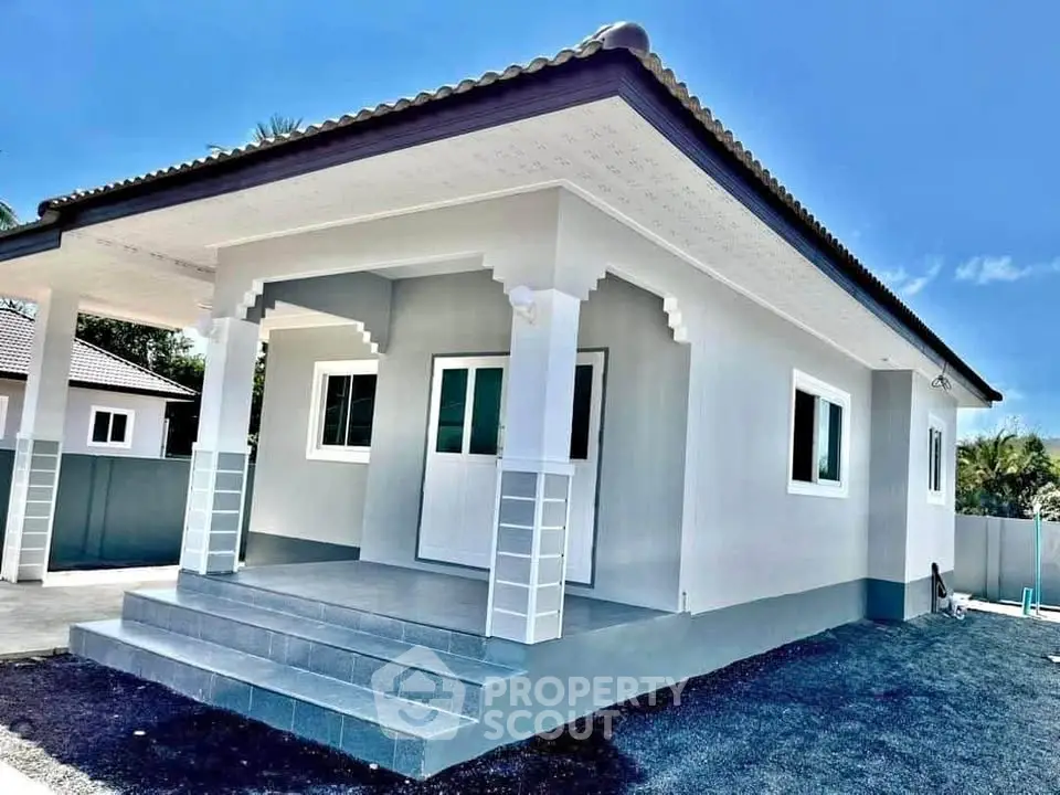 Charming single-story house with modern design and spacious front porch.